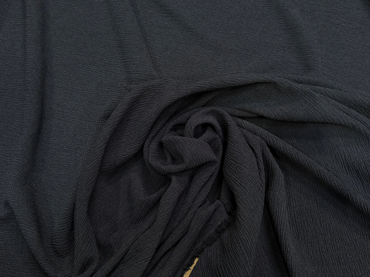 Tissu crêpe gaufré noir légèrement stretch au tombé plombant, effet double gaze